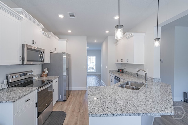 194 Gavin Way, Rincon, GA 31326 - kitchen featuring appliances with stainless steel finishes, light wood-type flooring, a peninsula, white cabinets, and recessed lighting