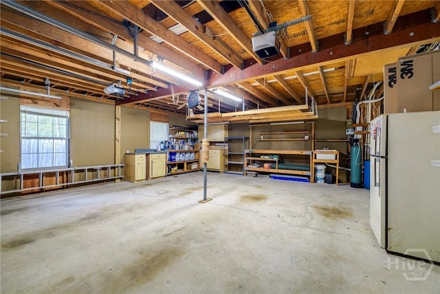 118 Plantation Way, Guyton, GA 31312 - basement with freestanding refrigerator, a workshop area, and a garage
