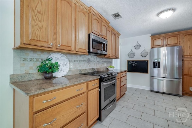 118 Plantation Way, Guyton, GA 31312 - kitchen featuring stainless steel appliances, backsplash, light tile patterned floors, a textured ceiling, and light stone counters