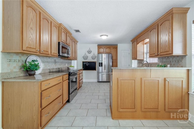 118 Plantation Way, Guyton, GA 31312 - kitchen with stainless steel appliances, a peninsula, tasteful backsplash, light tile patterned floors, and a textured ceiling