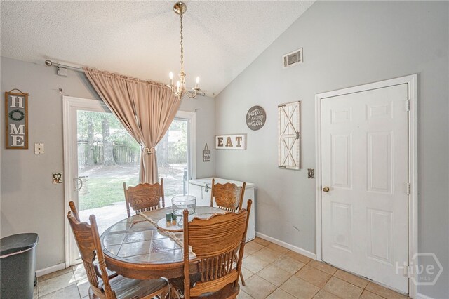 203 Deer Rd, Springfield, GA 31329 - dining room with lofted ceiling, a textured ceiling, a chandelier, and light tile patterned floors