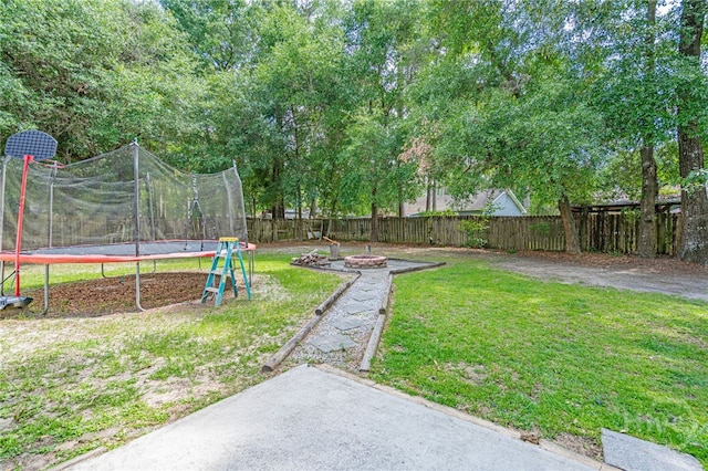 203 Deer Rd, Springfield, GA 31329 - fenced backyard featuring a trampoline and an outdoor fire pit