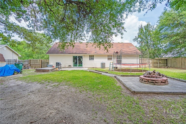 203 Deer Rd, Springfield, GA 31329 - back of property featuring an outdoor fire pit, a trampoline, a fenced backyard, and a patio area