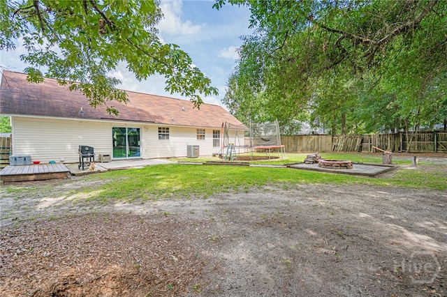 203 Deer Rd, Springfield, GA 31329 - fenced backyard featuring a fire pit, a deck, and a trampoline