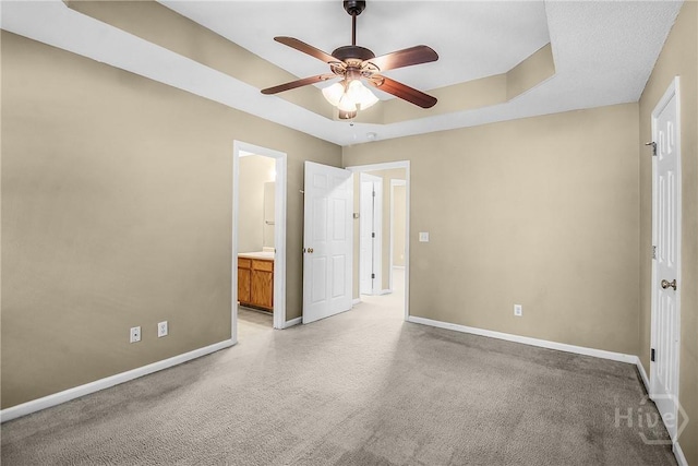 99 Dailey Dr, Guyton, GA 31312 - unfurnished bedroom with a raised ceiling, connected bathroom, light carpet, and ceiling fan