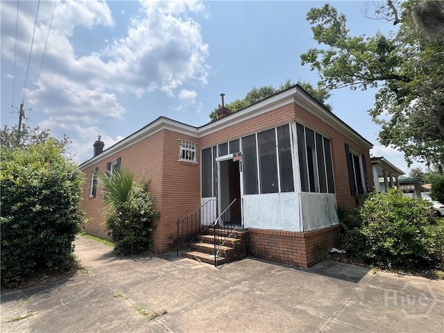 601 W 45th St, Savannah, GA 31405 - view of front of house featuring entry steps, brick siding, and a sunroom