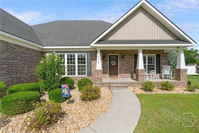 2016 Pippin Pl, Statesboro, GA 30461 - view of front of home featuring board and batten siding, brick siding, covered porch, a front yard, and a shingled roof