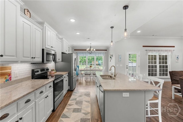 2016 Pippin Pl, Statesboro, GA 30461 - kitchen featuring appliances with stainless steel finishes, wood finished floors, a kitchen breakfast bar, ornamental molding, and backsplash