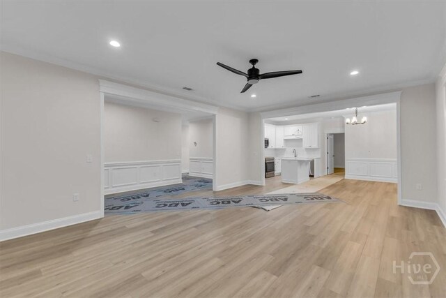 135 Houston St, Pooler, GA 31322 - unfurnished living room featuring ceiling fan, a decorative wall, a chandelier, light wood-type flooring, and a wainscoted wall