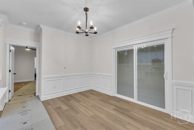 135 Houston St, Pooler, GA 31322 - unfurnished dining area featuring light wood-type flooring, a chandelier, ornamental molding, a wainscoted wall, and a decorative wall
