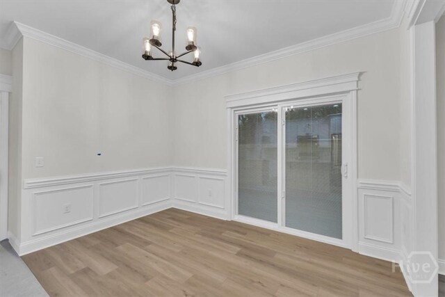 135 Houston St, Pooler, GA 31322 - unfurnished dining area with a chandelier, wood finished floors, ornamental molding, a wainscoted wall, and a decorative wall