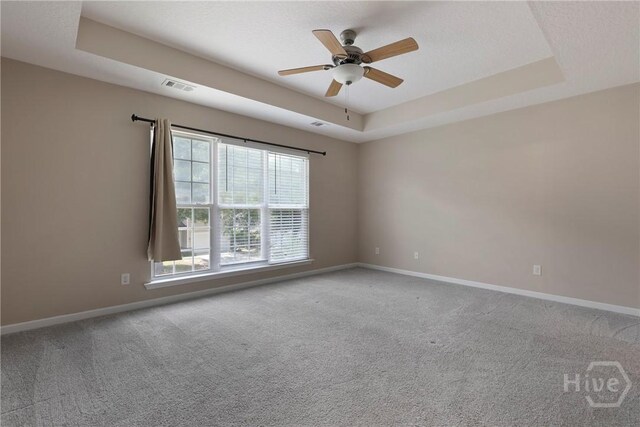 98 Peregrine Cir, Richmond Hill, GA 31324 - empty room with healthy amount of natural light, a raised ceiling, carpet floors, and a ceiling fan