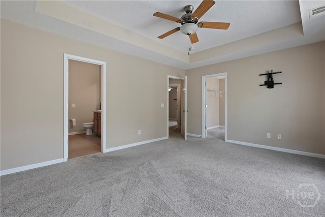98 Peregrine Cir, Richmond Hill, GA 31324 - unfurnished bedroom with a tray ceiling, carpet, a spacious closet, ensuite bathroom, and a closet