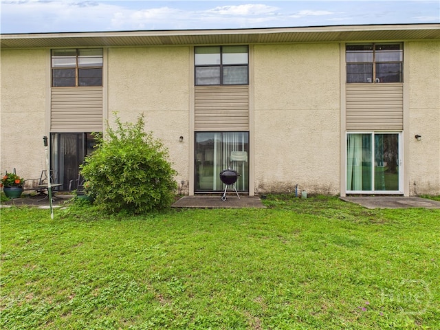 901 Olmstead Dr Unit 70, Hinesville, GA 31313 - back of property featuring stucco siding and a yard