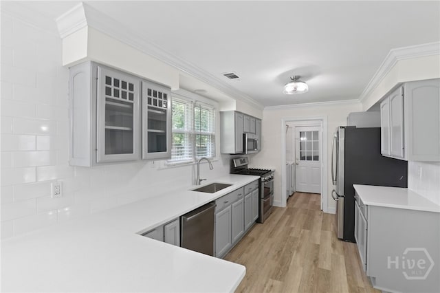 103 Olde Towne Rd, Savannah, GA 31410 - kitchen with appliances with stainless steel finishes, gray cabinets, ornamental molding, light countertops, and light wood finished floors