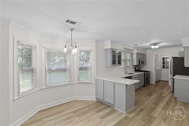 103 Olde Towne Rd, Savannah, GA 31410 - kitchen with stainless steel appliances, gray cabinetry, light countertops, a peninsula, and ornamental molding