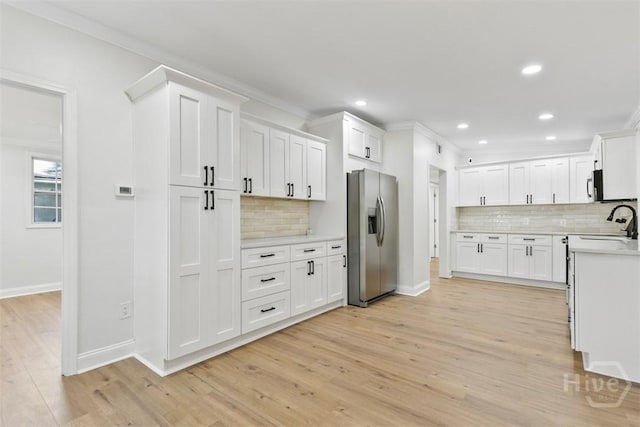 4630 Herty Dr, Savannah, GA 31405 - kitchen with stainless steel fridge, tasteful backsplash, light wood-type flooring, light countertops, and crown molding