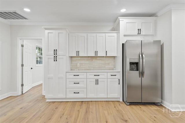 4630 Herty Dr, Savannah, GA 31405 - kitchen with stainless steel refrigerator with ice dispenser, white cabinetry, ornamental molding, decorative backsplash, and light wood-style flooring