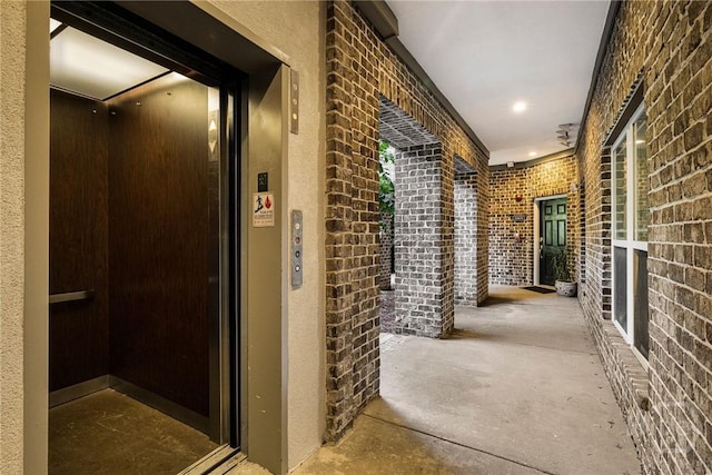 2805 River Oaks Dr Unit 2805, Richmond Hill, GA 31324 - hall featuring elevator, concrete flooring, and brick wall