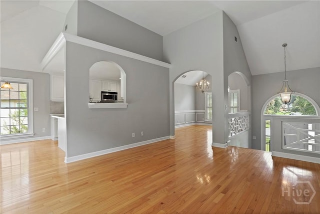 706 Southbridge Blvd, Savannah, GA 31405 - unfurnished room with high vaulted ceiling, light wood finished floors, arched walkways, and a chandelier
