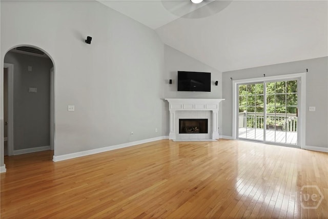 706 Southbridge Blvd, Savannah, GA 31405 - unfurnished living room with light wood finished floors, arched walkways, a fireplace with flush hearth, high vaulted ceiling, and a ceiling fan