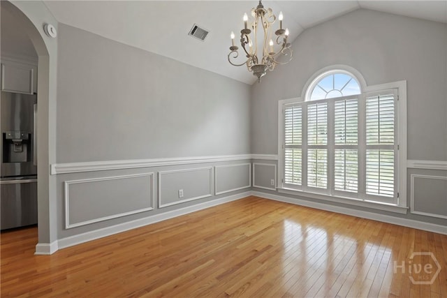 706 Southbridge Blvd, Savannah, GA 31405 - unfurnished room with vaulted ceiling, wood-type flooring, a chandelier, arched walkways, and wainscoting
