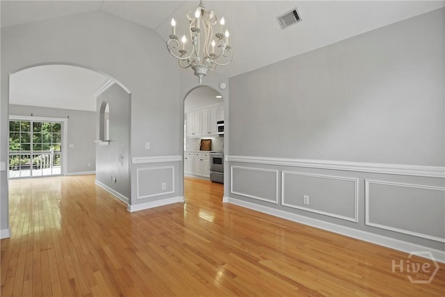 706 Southbridge Blvd, Savannah, GA 31405 - unfurnished dining area with lofted ceiling, arched walkways, light wood finished floors, a chandelier, and a decorative wall