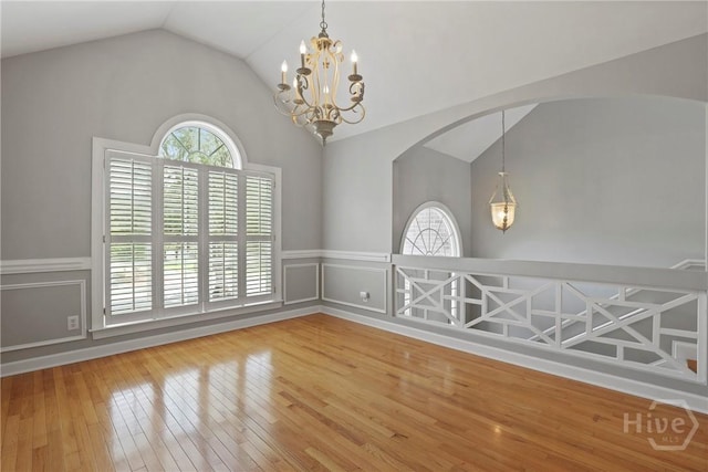 706 Southbridge Blvd, Savannah, GA 31405 - spare room featuring vaulted ceiling, a chandelier, hardwood / wood-style flooring, a wainscoted wall, and arched walkways