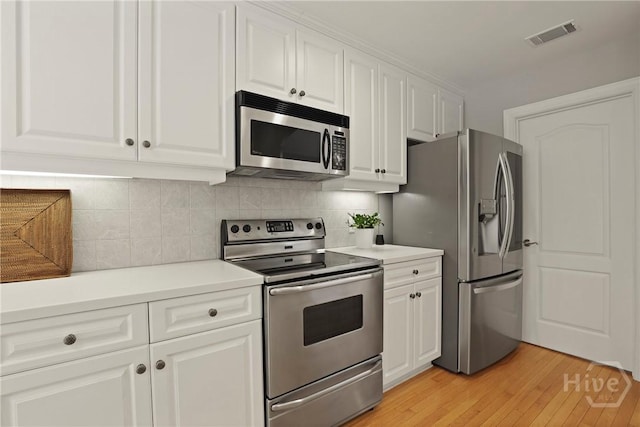 706 Southbridge Blvd, Savannah, GA 31405 - kitchen with stainless steel appliances, light wood-type flooring, white cabinetry, light countertops, and tasteful backsplash