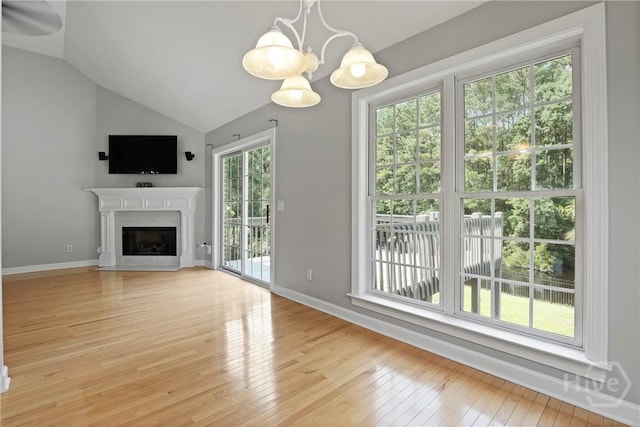 706 Southbridge Blvd, Savannah, GA 31405 - unfurnished living room with a chandelier, light wood-style flooring, a fireplace with flush hearth, and vaulted ceiling