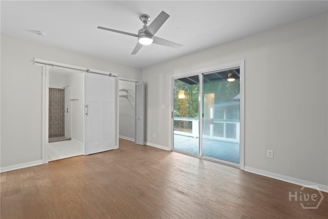 2133 Bacon Park Dr, Savannah, GA 31406 - unfurnished bedroom featuring access to exterior, wood finished floors, a barn door, ensuite bathroom, and ceiling fan