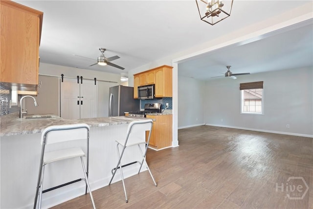 2133 Bacon Park Dr, Savannah, GA 31406 - kitchen featuring stainless steel appliances, ceiling fan, a peninsula, decorative backsplash, and dark wood-style floors