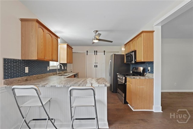2133 Bacon Park Dr, Savannah, GA 31406 - kitchen with appliances with stainless steel finishes, a peninsula, tasteful backsplash, ceiling fan, and dark wood-type flooring