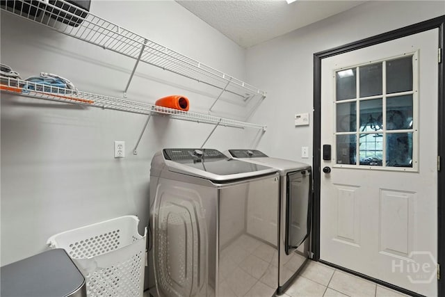 31 Pembroke Pl, Pembroke, GA 31321 - washroom featuring washer and clothes dryer, light tile patterned flooring, and a textured ceiling