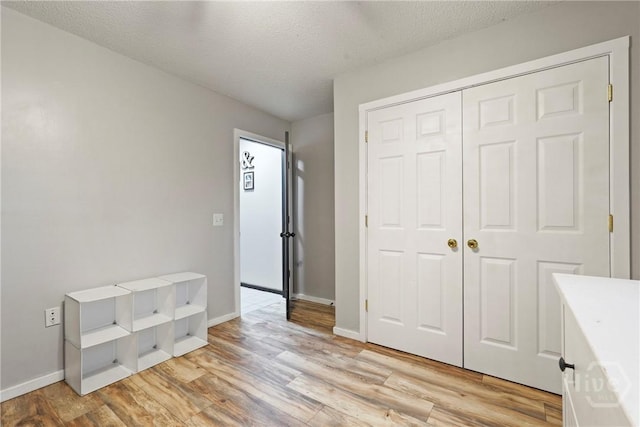 31 Pembroke Pl, Pembroke, GA 31321 - unfurnished bedroom with light wood-style floors, a textured ceiling, and a closet