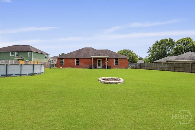 308 NE Mancey Garrason Loop, Ludowici, GA 31316 - rear view of house featuring a fire pit, a fenced backyard, and brick siding