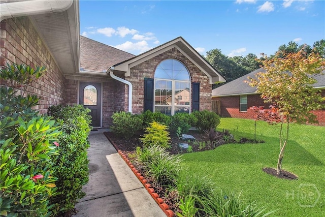 116 Gloucester Dr, Midway, GA 31320 - doorway to property featuring brick siding, a lawn, and roof with shingles