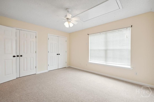301 Marshview Dr, Richmond Hill, GA 31324 - unfurnished bedroom featuring multiple closets, carpet flooring, attic access, a textured ceiling, and a ceiling fan