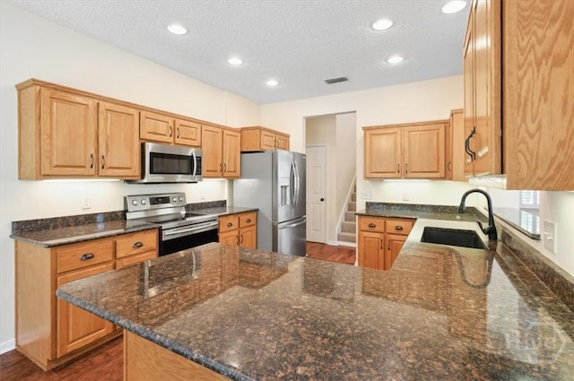 301 Marshview Dr, Richmond Hill, GA 31324 - kitchen featuring stainless steel appliances, a peninsula, a textured ceiling, recessed lighting, and dark stone countertops