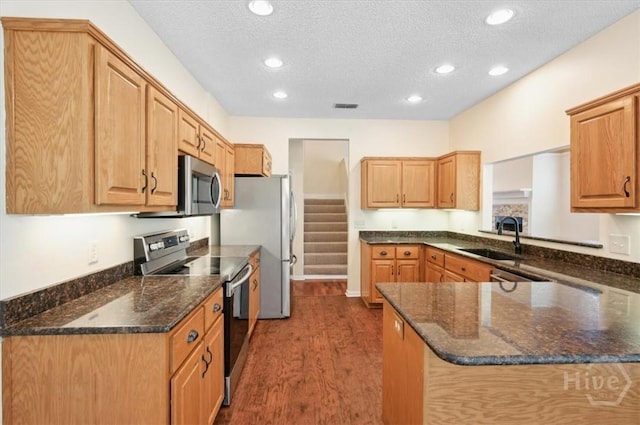 301 Marshview Dr, Richmond Hill, GA 31324 - kitchen featuring appliances with stainless steel finishes, dark wood finished floors, recessed lighting, a textured ceiling, and dark stone counters