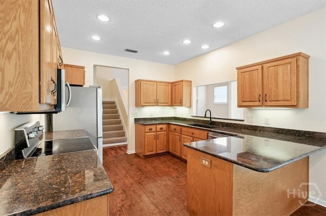 301 Marshview Dr, Richmond Hill, GA 31324 - kitchen with electric range oven, a peninsula, dark wood-style floors, a textured ceiling, and stainless steel microwave