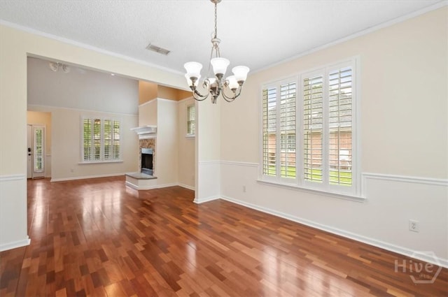 301 Marshview Dr, Richmond Hill, GA 31324 - unfurnished dining area featuring a chandelier, wood finished floors, crown molding, and a fireplace with raised hearth