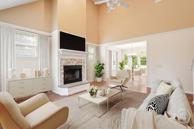 301 Marshview Dr, Richmond Hill, GA 31324 - living area featuring wood finished floors, a high ceiling, a stone fireplace, ceiling fan, and a chandelier