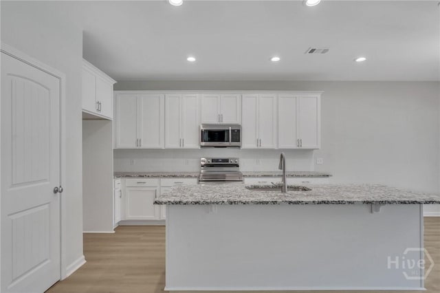 101 Kenwood Cir, Savannah, GA 31302 - kitchen with stainless steel appliances, light stone counters, white cabinets, light wood finished floors, and recessed lighting