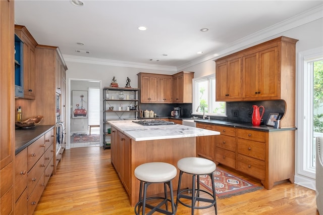 3 She Crab Cir, Savannah, GA 31411 - kitchen with open shelves, a kitchen island, light wood-type flooring, backsplash, and brown cabinetry