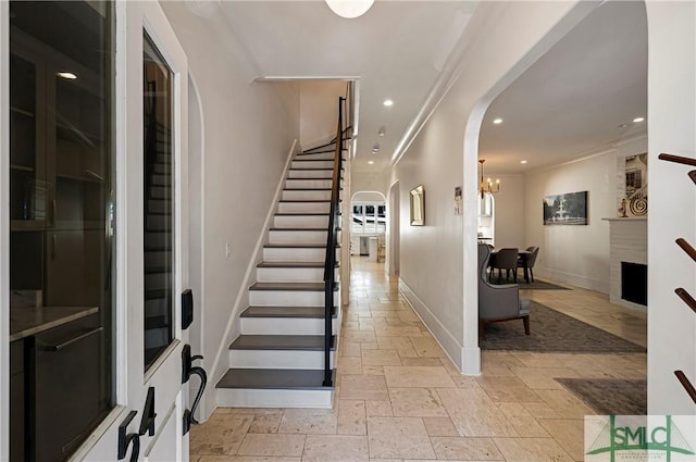 52-56 E Broad St, Savannah, GA 31401 - foyer entrance with arched walkways, stairway, stone tile flooring, ornamental molding, and recessed lighting