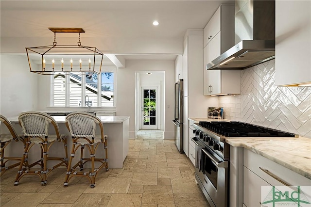 52-56 E Broad St, Savannah, GA 31401 - kitchen with wall chimney range hood, appliances with stainless steel finishes, stone tile floors, backsplash, and white cabinets