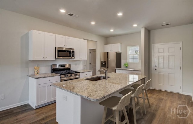 131 Crimson Ln, Savannah, GA 31302 - kitchen featuring stainless steel appliances, dark wood finished floors, a kitchen breakfast bar, light stone counters, and white cabinets