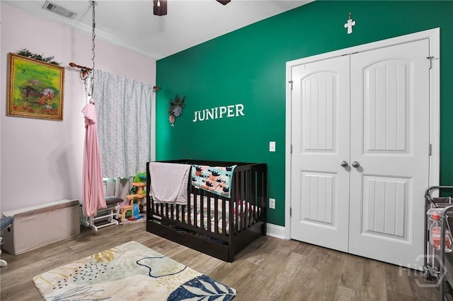 1416 Hillridge Dr, Darien, GA 31305 - bedroom featuring a crib, wood finished floors, a closet, and ceiling fan
