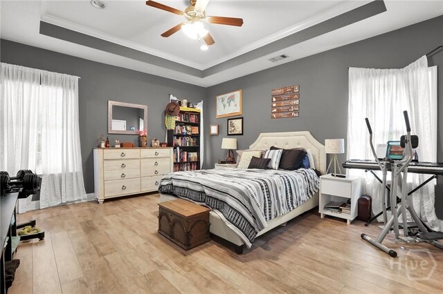 1416 Hillridge Dr, Darien, GA 31305 - bedroom featuring a raised ceiling, light wood-style flooring, crown molding, and a ceiling fan
